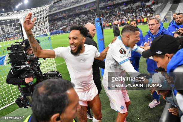 Marseille's French-Gabonese forward Pierre-Emerick Aubameyang and Marseille's Moroccan French midfielder Amine Harit celebrate winning the UEFA...