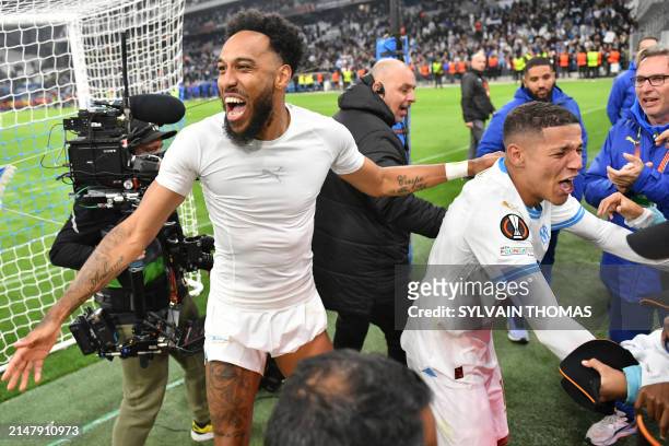 Marseille's French-Gabonese forward Pierre-Emerick Aubameyang and Marseille's Moroccan French midfielder Amine Harit celebrate after winning the UEFA...