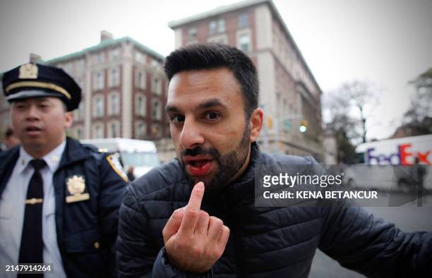 Man that got hit by other protestors points to a wound as Pro-Palestinian protesters march outside Columbia University in New York City on April 18,...