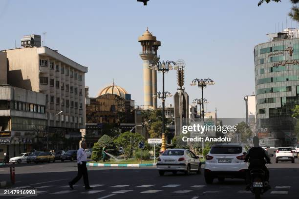 People walk on the streets of Tehran as they continue their daily lives after the explosions heard in Isfahan and Tabriz cities of Iran, in Tehran,...