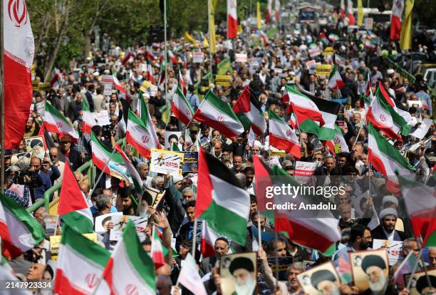 People march with flags and banners to celebrate Iran's April 13 attack on Israel and protest Israel, which is accused of carrying out the attack...