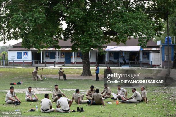Policemen rest outside a polling station during the first phase of voting of India's general election at Bakshirhat area in Cooch Behar district,...
