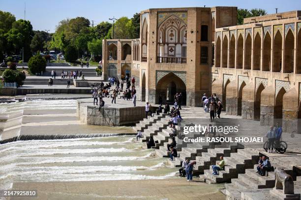People visit the Khaju Bridge in Iran's central city of Isfahan on April 19, 2024. World leaders appealed for calm on April 19 after reported Israeli...