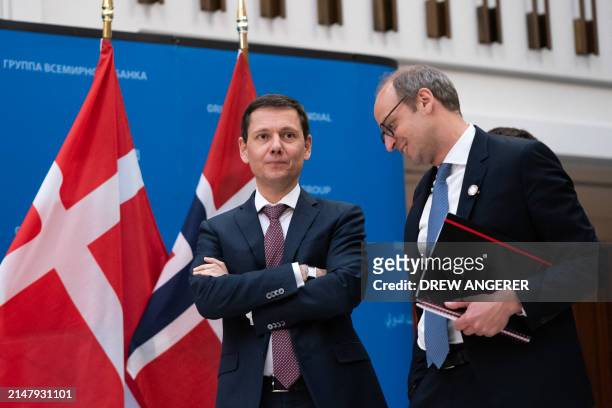 French Director General of the Treasury Bertrand Dumont speaks with an aide while gathering for a group photo of the World Bank Group and Heads of...