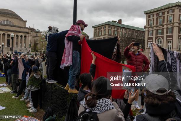 Students use blankets to block people from recording their faces during the third day of demonstration in support of Palestinians in Columbia...