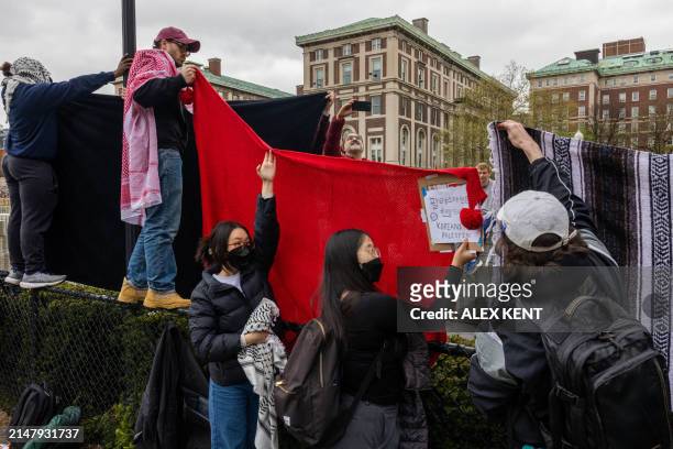 Students use blankets to block people from recording their faces during the third day of demonstration in support of Palestinians in Columbia...
