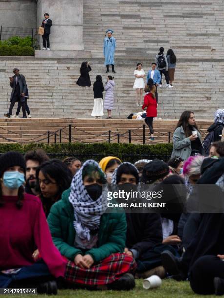 Pro-Palestinian students and activists camp out on the campus of Columbia University as others pose in their caps and gowns ahead of graduation in...