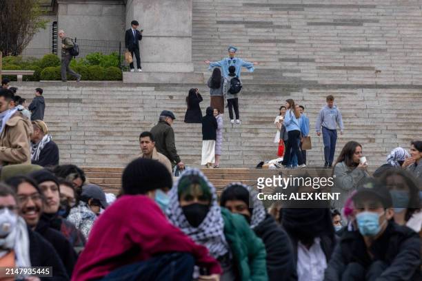 Pro-Palestinian students and activists camp out on the campus of Columbia University as others pose in their caps and gowns ahead of graduation in...