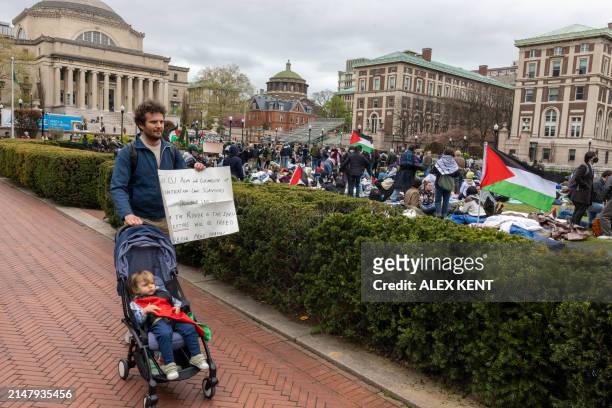 Man walks with a sign as pro-Palestinian students and activists camp out on the campus of Columbia University in New York City on April 19, 2024....