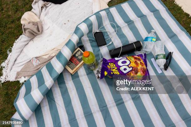The book "The Autobiography of Malcolm X" is seen alongside beverages and a bag of chips on a mat as pro-Palestinian students and activists camp out...