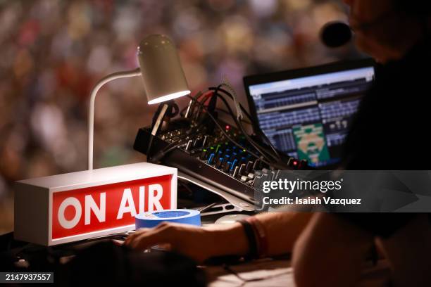 An "On Air" sign is shown as a radio announcer works at the table during a baseball game between Florida State Seminoles and the Wake Forest Demon...