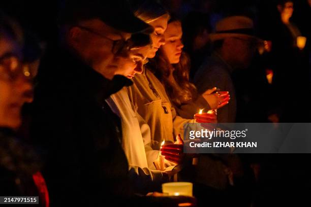 People attend a candlelight vigil for the victims of a stabbing attack at the Bondi Junction Westfield shopping centre in Sydney on April 21, 2024.