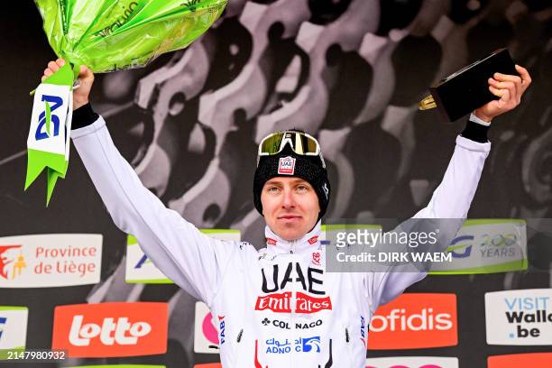 Team Emirates' Slovenian cyclist Tadej Pogacar celebrates on the podium after winning the Liege-Bastogne-Liege one day cycling race 5 km round-trip...