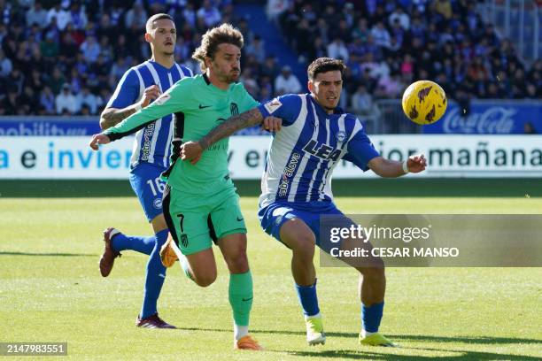 Atletico Madrid's French forward Antoine Griezmann and Alaves' Spanish defender Javi Lopez vie for the ball during the Spanish league football match...