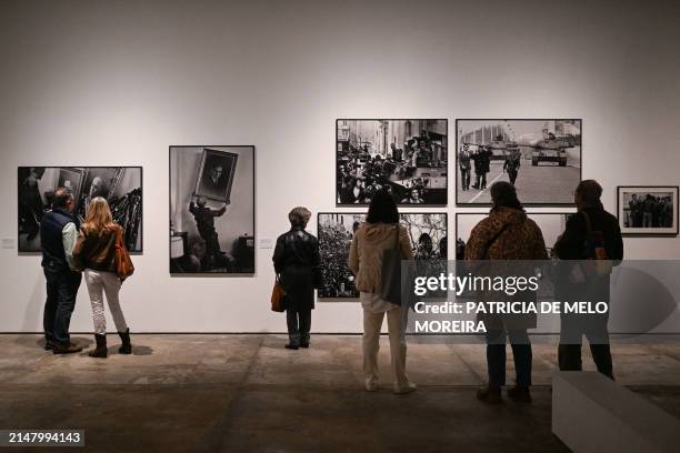 People visit Portuguese photojournalist Eduardo Gageiro's exhibition "Factum", about the 1974 Carnation Revolution, at Cordoaria in Lisbon on April...