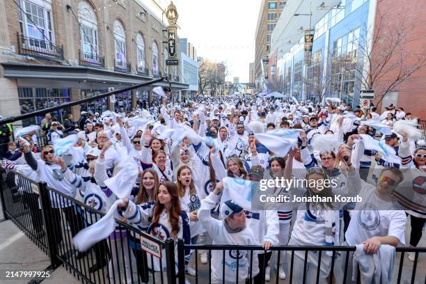 Fans show their support for the Winnipeg Jets as they cheer and wave white towels during the Whiteout Street Party prior to NHL action between the...