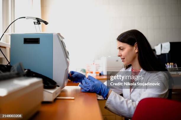young medical nurse analyzing blood tests - immunology stock pictures, royalty-free photos & images