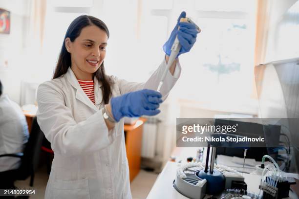 female biologist pip petting cells - precision oncology stock pictures, royalty-free photos & images