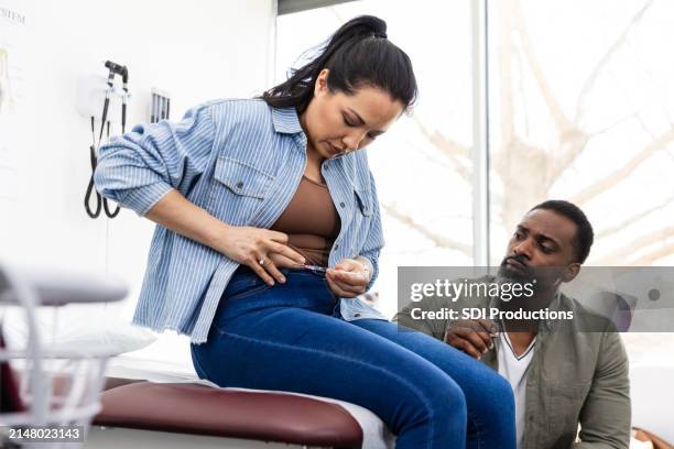 husband watches intently as wife injects medication in her abdomen - subcutaneous stock pictures, royalty-free photos & images