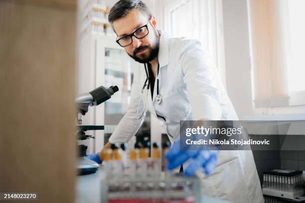 bel tecnico di laboratorio che usa un telescopio - laboratorio medico foto e immagini stock