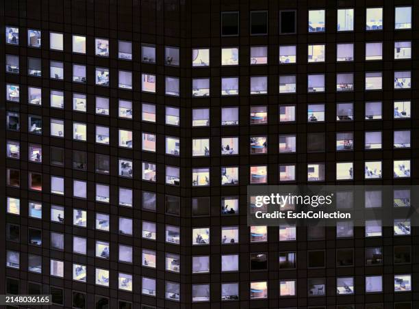 modern office building with office workers and business people working late - vierkant compositie stockfoto's en -beelden
