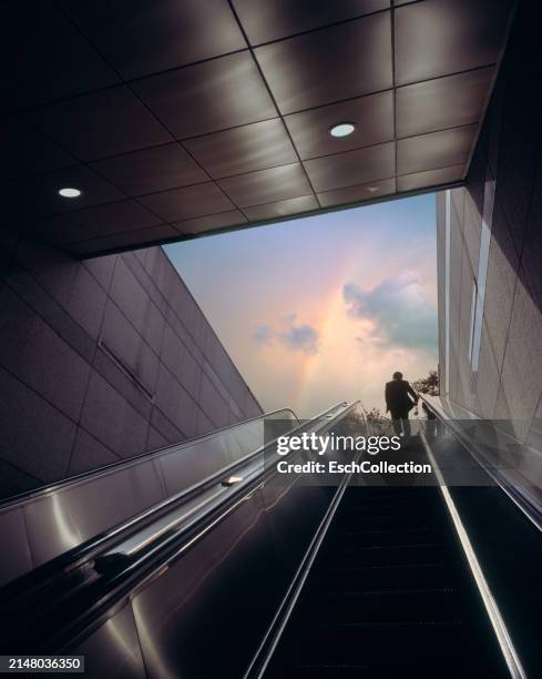 businessman on escalator moving towards sky with rainbow - light at the end of the tunnel stock pictures, royalty-free photos & images