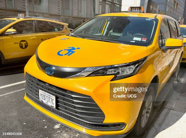 The wheelchair logo on the hood of a New York City yellow taxi cab indicates the vehicle is wheelchair accessible to accommodate passengers with...