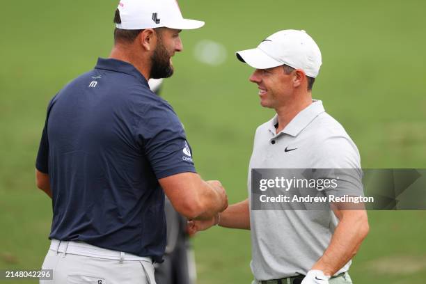 Jon Rahm of Spain and Rory McIlroy of Northern Ireland hug in the practice area prior to the 2024 Masters Tournament at Augusta National Golf Club on...