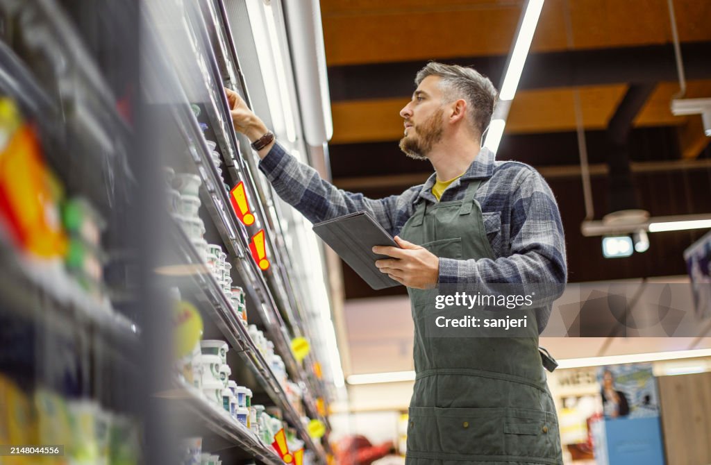 Employé de vente au détail organisant les étagères des magasins