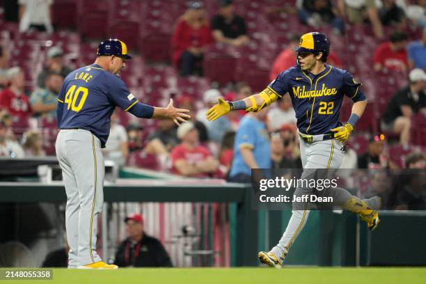 Christian Yelich of the Milwaukee Brewers celebrates with Jason Lane after hitting a two-run home run against the Cincinnati Reds in the seventh...