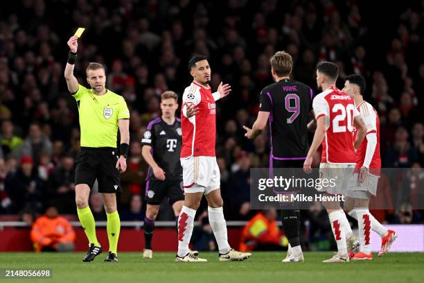 Match referee Glenn Nyberg shows a yellow card to Harry Kane of Bayern Munich during the UEFA Champions League quarter-final first leg match between...