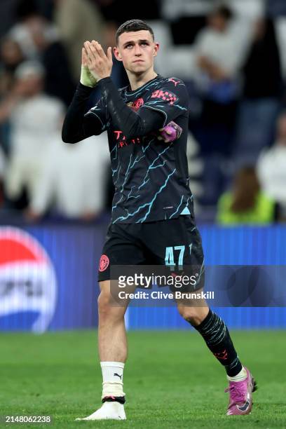 Phil Foden of Manchester City is seen missing a boot after picking up an injury as he applauds the fans after the draw in the UEFA Champions League...