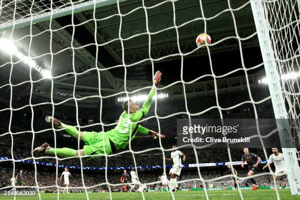Andriy Lunin of Real Madrid fails to save a shot from Phil Foden of Manchester City, resulting in Manchester City's second goal during the UEFA...