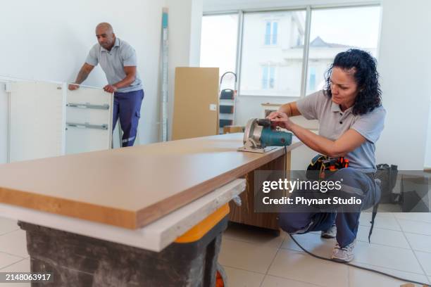 kitchen fitters installing cabinets, two joiners installing a kitchen - countertop installation stock pictures, royalty-free photos & images