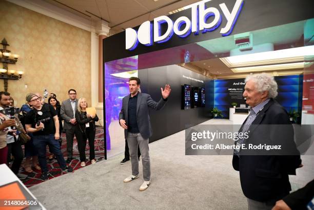 Jed Harmsen from Dolby Laboratories and Ioan Allen speak during a guided tour of the Trade Show Floor during CinemaCon, the official convention of...