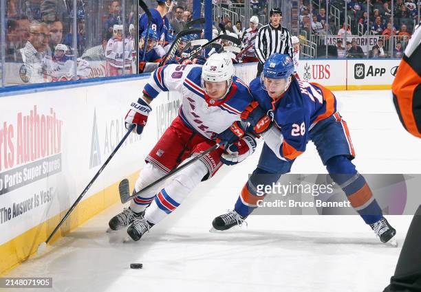 Alexander Romanov of the New York Islanders checks Will Cuylle of the New York Rangers during the first period at UBS Arena on April 09, 2024 in...