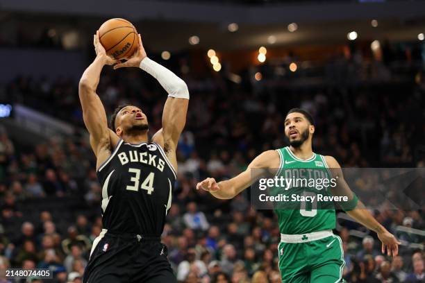 Giannis Antetokounmpo of the Milwaukee Bucks is defended by Jayson Tatum of the Boston Celtics during the first half of a game at Fiserv Forum on...