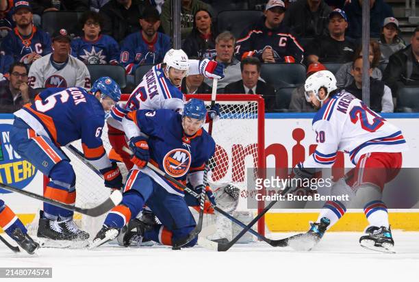 Adam Pelech of the New York Islanders defends against Chris Kreider of the New York Rangers during the second period at UBS Arena on April 09, 2024...