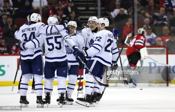 Mark Giordano of the Toronto Maple Leafs is congratulated by teammates after he scored during the second period against the New Jersey Devils at...