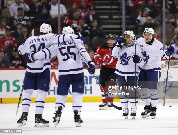 Mark Giordano of the Toronto Maple Leafs is congratulated by teammates after he scored during the second period against the New Jersey Devils at...