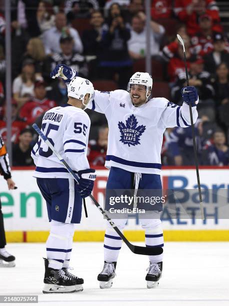 Mark Giordano of the Toronto Maple Leafs is congratulated by teammate Auston Matthews after Giordano scored during the second period against the New...
