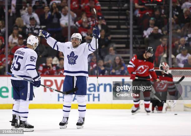Mark Giordano of the Toronto Maple Leafs is congratulated by teammate Auston Matthews after Giordano scored during the second period as Brendan Smith...