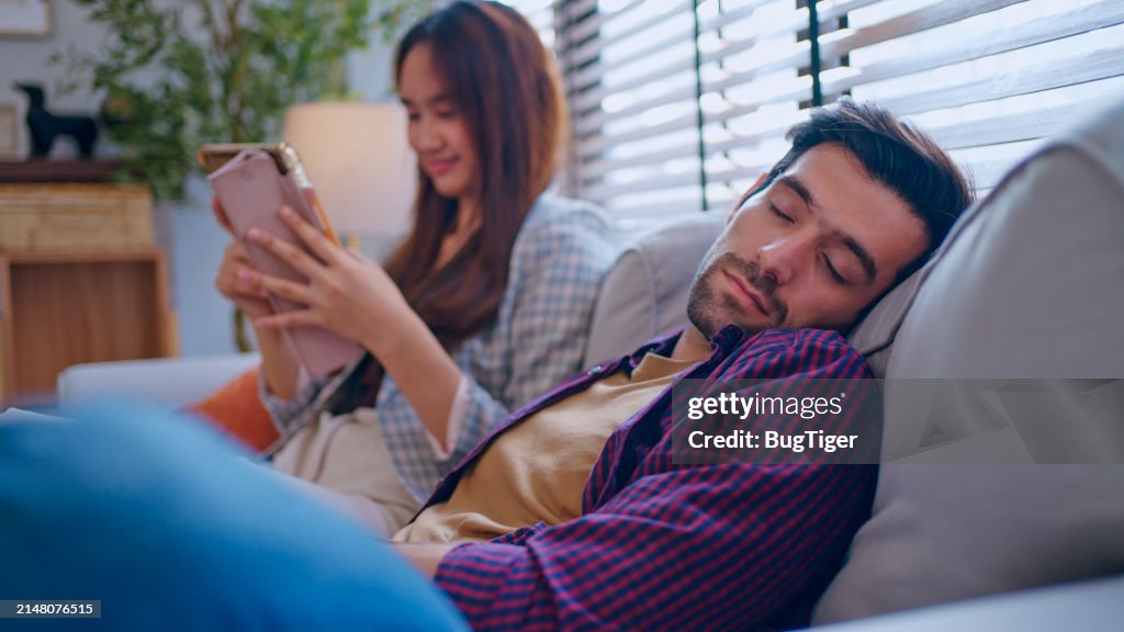Relaxed young man sleeping leaning on cozy sofa.