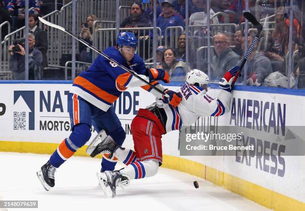 Noah Dobson of the New York Islanders checks Vincent Trocheck of the New York Rangers in the final minute of play of the third period at UBS Arena on...