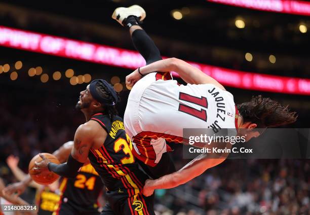 Jaime Jaquez Jr. #11 of the Miami Heat fouls Wesley Matthews of the Atlanta Hawks as he falls over top of him during the fourth quarter at State Farm...