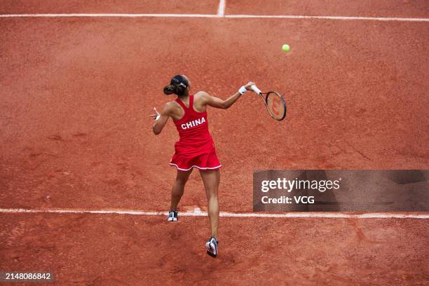 Zheng Qinwen of China serves in the Women's Singles match against Yang Ya Yi of Chinese Taipei during the Billie Jean King Cup 2024 tennis tournament...