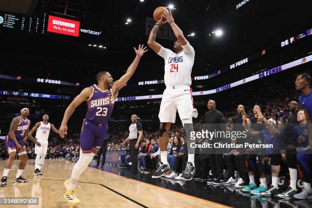 Norman Powell of the LA Clippers attempts a three-point shot over Eric Gordon of the Phoenix Suns during the second half of the NBA game at Footprint...