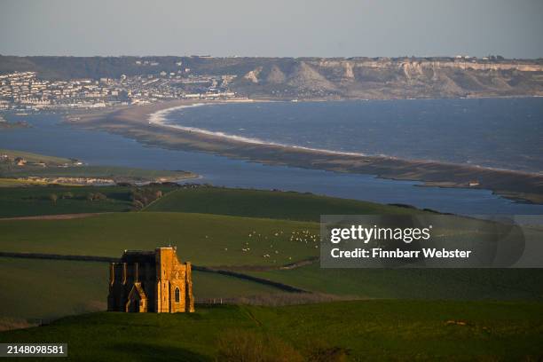 The sun sets on St Catherine's Chapel above the village of Abbotsbury, overlooking the Isle of Portland and the Jurassic Coast’s Chesil Beach and...