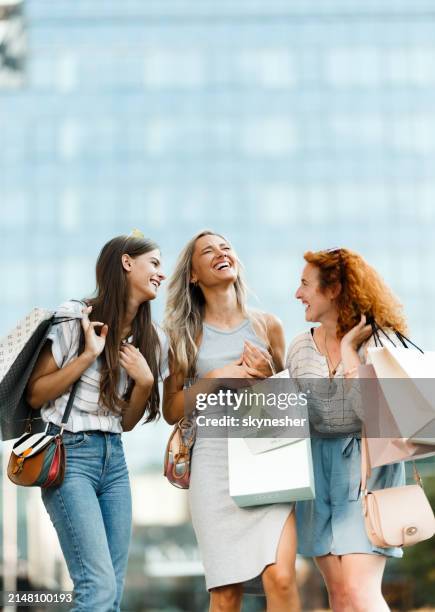 fröhliche freundinnen, die sich beim einkaufen in der stadt unterhalten. - einkaufen stock-fotos und bilder
