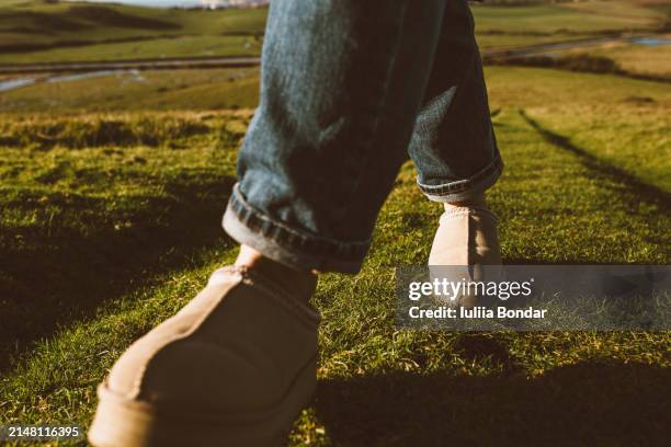 close up shoes hiking on a green grass - sheepskin boot stock pictures, royalty-free photos & images